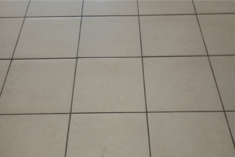 Dirty tile floor with dark grout lines before professional cleaning in Port Charlotte Florida